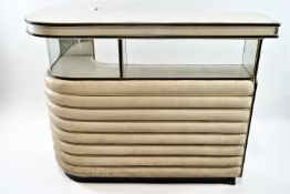 A 1960's retro bar with Formica top above a mirrored section above ribbed vinyl upholstered sides,