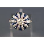 A white metal cluster ring. Set with a central round brilliant cut diamond of approx. 0.50cts.