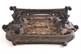 A cast iron boot scraper, of rectangular form with c scroll motifs,