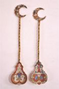 Two gilt Russian spoons with enamelled crescent finials over twisted stems set a pear shaped,