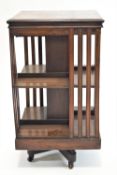An early 20th century mahogany revolving bookcase, the "X" base on casters, 84cm high, 47cm wide,