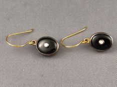 A yellow and white metal pair of drop earrings each set with onyx