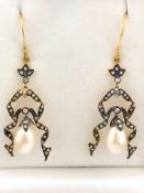 A yellow and white metal pair of drop earrings,