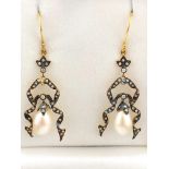 A yellow and white metal pair of drop earrings,