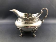 A silver sauce boat with gadrooned edge with pierced decoration and scroll handle
