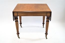 A Victorian mahogany drop leaf writing table on turned tapering legs with brass casters, 73 cm high,