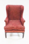 A 19th century style wingback armchair on square mahogany legs with unusual brass casters,