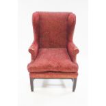 A 19th century style wingback armchair on square mahogany legs with unusual brass casters,