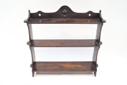 A 19th century oak three tier wall shelf, with shaped and pierced crest,