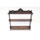 A 19th century oak three tier wall shelf, with shaped and pierced crest,