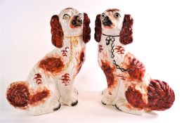 Two pairs of Staffordshire pottery dogs, one pair picked out in gilt, the other in iron red enamels,