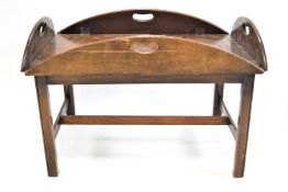 A mahogany coffee table with butler's tray top on square legs linked by an H stretcher, 42cm high,