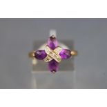 A yellow metal dress ring set with four faceted cut amethyst