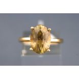 A yellow metal single stone ring. Set with a fancy faceted cut yellowish green chrysoberyl.