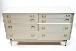 A G plan chest of eight drawers with painted grey finish, brass handles and square tapering legs,