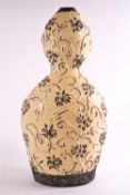 An Art pottery earthenware double gourd vase, glazed in cream,