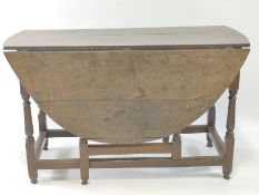 An 18th century gateleg kitchen table with baluster turned legs and stretchers, 74cm high,