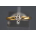 A yellow and white metal single stone ring set with a round brilliant cut diamond