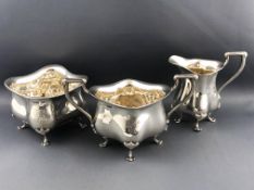 A silver sugar bowl and milk jug of belled, shaped square form raised on four cabriole legs,