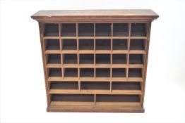 A pine standing cabinet inset with pigeon holes beneath a moulded cornice, 96cm high, 103cm wide,