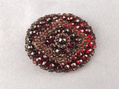 A large cluster brooch set with garnet (untested stones) . Pin and hook catch.