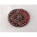 A large cluster brooch set with garnet (untested stones) . Pin and hook catch.