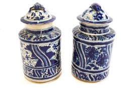A pair of Puebla tin glazed earthenware cylindrical vases and covers with tortoise finials,