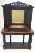 A Victorian carved oak hall stand with pierced lion mask crest above a rectangular mirror,
