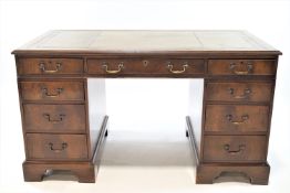 A George III style mahogany pedestal desk with green leather inset top above three drawers