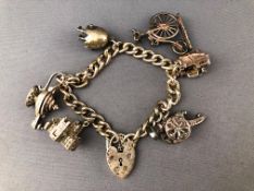 A white metal curb link bracelet having three fixed charms and three loose charms.