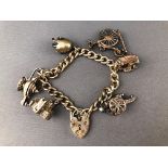 A white metal curb link bracelet having three fixed charms and three loose charms.