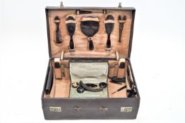 Two cased dressing sets, one of suitcase form in dark brown pigskin,