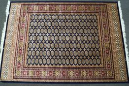 A machine woven Bokhara style carpet with thirteen rows of medallions on a blue ground