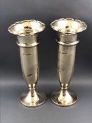 A pair of silver spill vases with gadrooned lips over bullet shaped bodies
