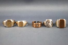 A collection of five rings of variable designs. Two are stamped 9ct on silver.