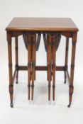 An unusual nest of three tables on turned tapering legs and brass casters,