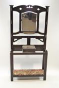 An oak hall stand, with pierced and mirrored back above a box with hinged cover, on square legs,