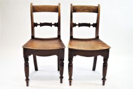 A pair of 19th century elm and mahogany chairs with shaped horizontal splats and solid seats