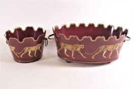 Two Tole two handled jardinieres, each with applied prints of leopards on a red ground,