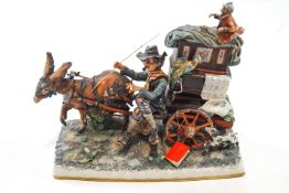 A Capodimonte figure group of a Hurdy gurdy player being pulled along by a donkey and