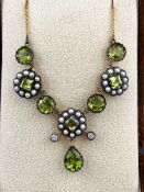 A yellow and white metal centrepiece necklace having floral cluster designs set with peridot,