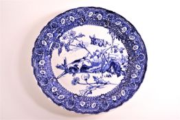 A Doulton series blue printed charger, decorated with a dog chasing a rabbit, in a floral border,