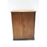 A mahogany side cabinet of plain rectangular form with two panelled doors, raised on a plinth base,