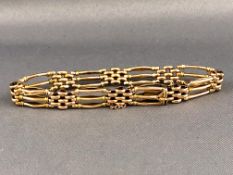 A yellow metal four bar gate and brick link bracelet. Push in clasp with fitted safety chain.