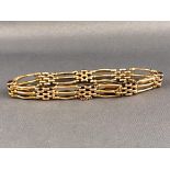 A yellow metal four bar gate and brick link bracelet. Push in clasp with fitted safety chain.