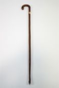 A walking stick with gold band and a walking cane with turned ivory handle,