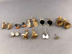 A collection of eight pairs of earrings of various designs.