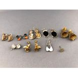 A collection of eight pairs of earrings of various designs.