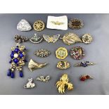 A collection of twenty brooches of various designs. Finished in base metals and paste stones.