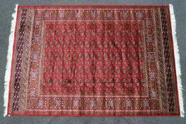 A machine woven Keishan style carpet with eleven rows of medallions